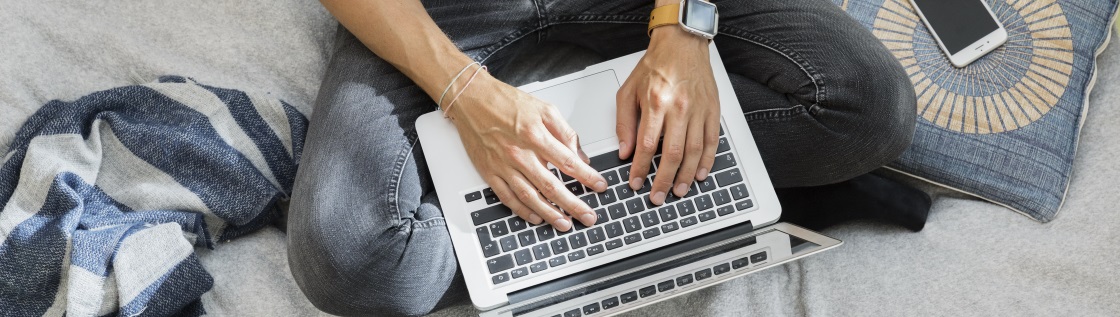 Person sidder med sin laptop på skødet